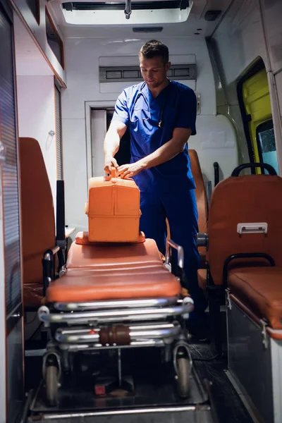 Санитар стоит с медицинской сумкой в машине скорой помощи — стоковое фото