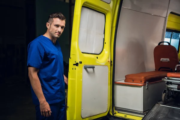 El médico forense de uniforme médico azul se para y mira a la cámara —  Fotos de Stock