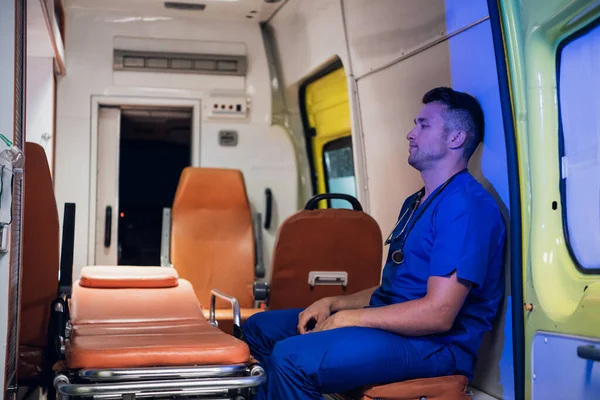 Un infirmier en uniforme est assis à l'intérieur de la voiture d'ambulance — Photo
