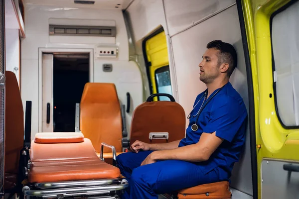 Tired corpsman sits inside the ambulance car