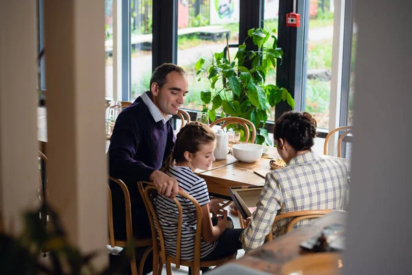 Young family exchanging christmas gifts at dinner — Stock Photo, Image