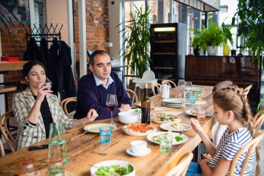 Kafede çocuklu bir aile, aileler şarap içiyor..