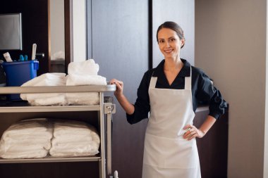 Üniformalı, temiz havlu taşıyan bir otel personeli.