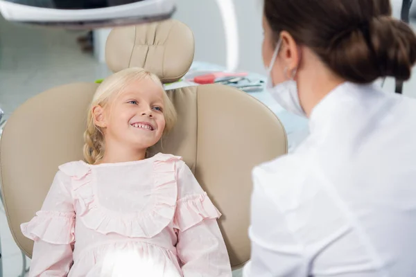 Κοντινό πλάνο ενός χαριτωμένου, μικρού κοριτσιού στην καρέκλα των οδοντιάτρων που περιμένει να ελεγχθεί. — Φωτογραφία Αρχείου