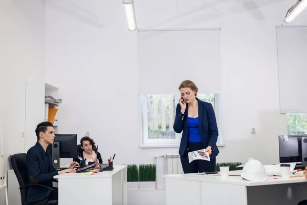 Eine Frau telefoniert in einem Großraumbüro, während sie herumläuft — Stockfoto