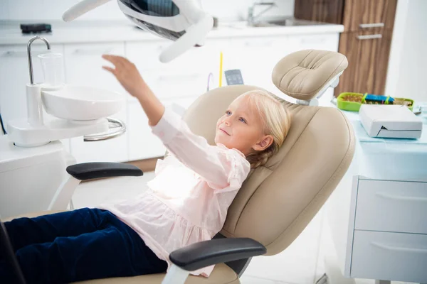 Mała dziewczynka siedząca na krześle dentystycznym — Zdjęcie stockowe