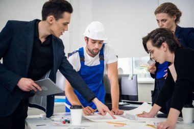 Masanın etrafında iki başarılı iş kadını ve iki işadamı yeni projeleri tartışıyor.