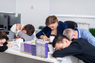 Meslektaşları mola verirken çok çalışan güzel bir kadının portresi. Büyük, modern bir ofiste oturan meslektaşlar. Şirket toplantısı konsepti
