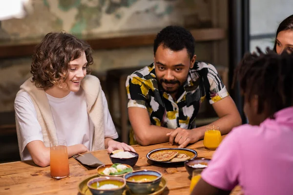 Multi-etnische groep studenten die eten in een café — Stockfoto
