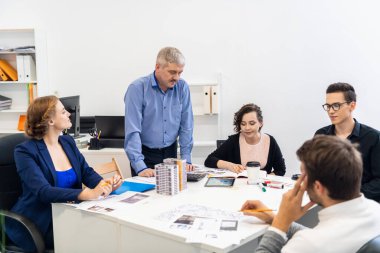 Ofisinde bir yöneticiyle iş görüşmesi. Ekip projelerini sunuyor.