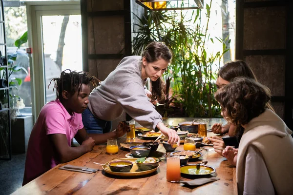 Un groupe de jeunes amis partageant un repas dans un café — Photo