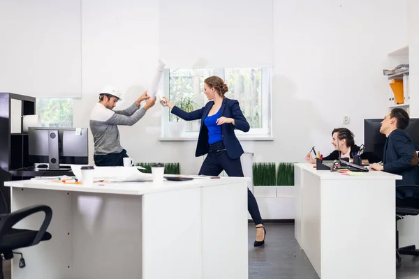 Junge Konstrukteure kämpfen mit dem, was im Büro rollt — Stockfoto