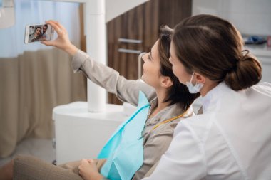 Kadın bir hasta doktoruyla selfie çekiyor.