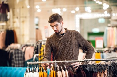 Mağazada kız arkadaşına hediye arayan genç bir adam.