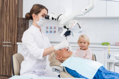 Bir anne ve küçük kızı dişçi muayenehanesinde.