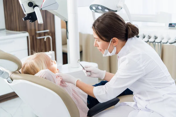Pessoas, medicina, estomatologia e conceito de cuidados de saúde - Imagem de uma menina com os dentes verificados por uma médica na clínica — Fotografia de Stock