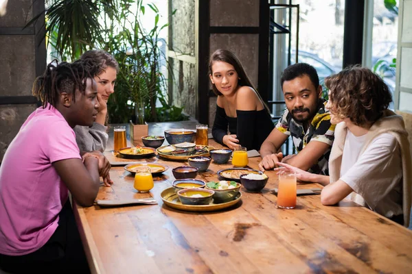 Multi-etnische studenten ontmoeten elkaar in een Aziatisch café — Stockfoto