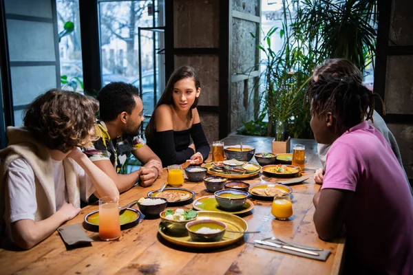 Cinq jeunes amis assis à la table dans un café, bavarder, hav — Photo