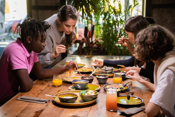 Un groupe de jeunes amis partageant un repas dans un café — Photo