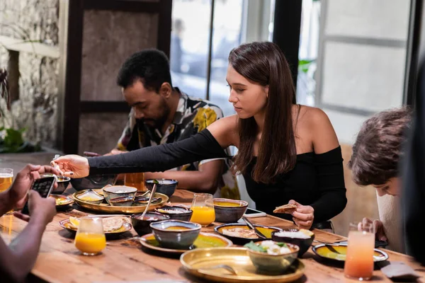 Joven chica bonita teniendo una comida con sus amigos — Foto de Stock