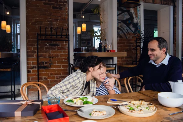 Une famille de trois personnes profitant de leur temps dans un café — Photo