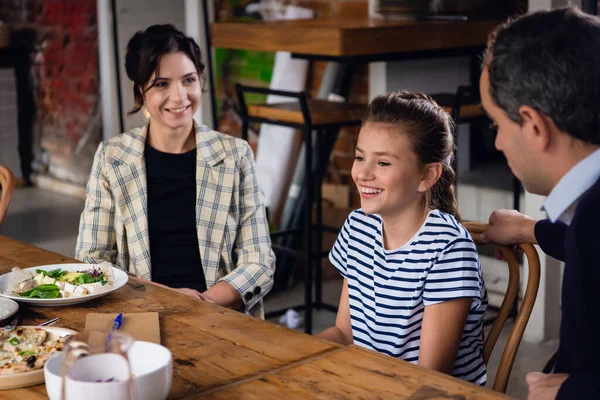 Een gezin van drie die genieten van hun tijd in een café. — Stockfoto