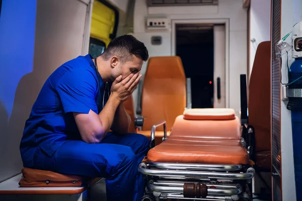 Перегруженный работой парамедик засыпает в машине скорой помощи — стоковое фото