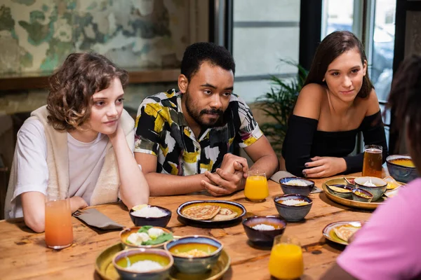 Groupe multi-ethnique d'amis passant du temps dans un café — Photo