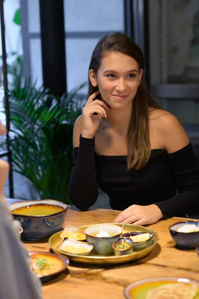 Portrait d'une jeune fille assise et souriante dans un café — Photo