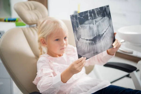 Ένα κοριτσάκι με ακτινογραφία σε καρέκλα οδοντιάτρου. Οδοντιατρική, ιατρική — Φωτογραφία Αρχείου