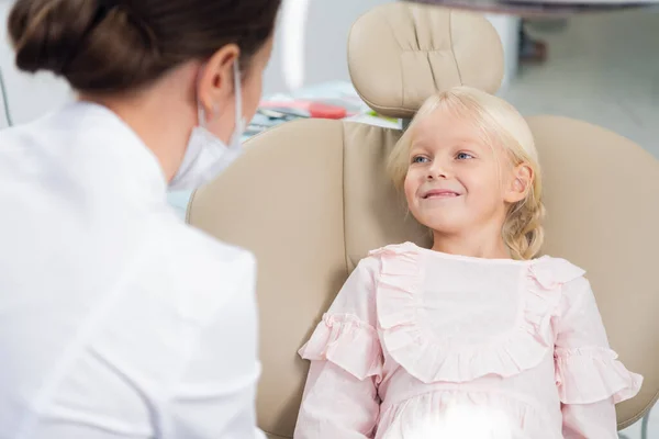 Una linda niña en el consultorio de dentistas hablando con su pediatra — Foto de Stock