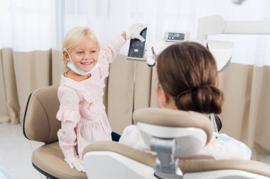 Bir dişçi kliniğinde doktor gibi davranan bir kız var.