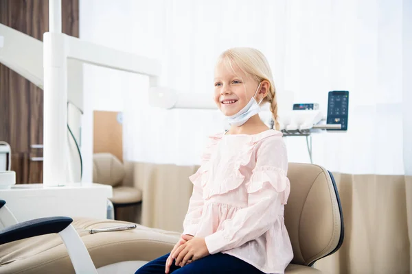 Una piccola paziente dentista soddisfatta che mostra il suo sorriso perfetto a poppa — Foto Stock