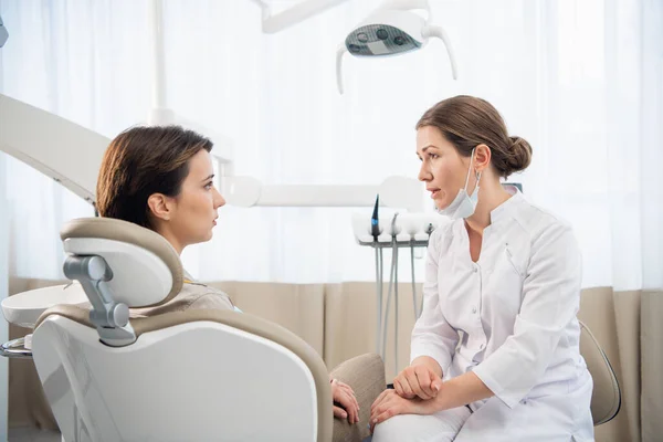 Η γυναίκα οδοντίατρος συζητά έκθεση με τον ασθενή της στην κλινική — Φωτογραφία Αρχείου