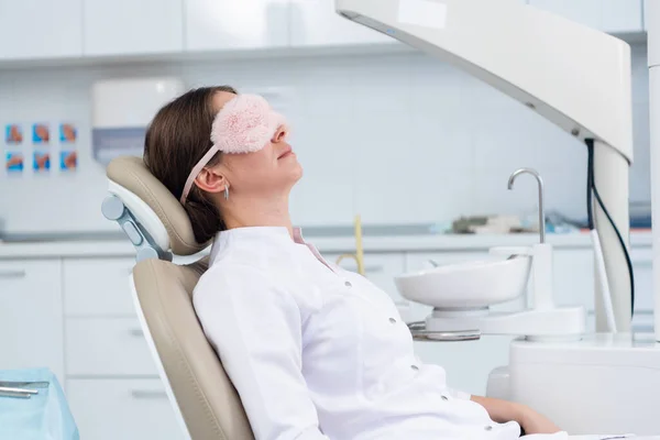 Młoda kobieta, dentysta lub pacjent, leży na krześle w — Zdjęcie stockowe