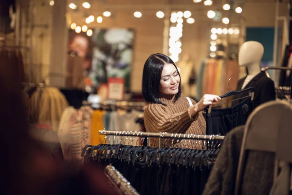 Eine Frau beim Einkaufen. Ladendieb schaut sich Bekleidung im Haus an — Stockfoto