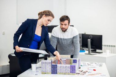 Genç mimar bürosu çalışanları inşaat modunu tartışıyor.