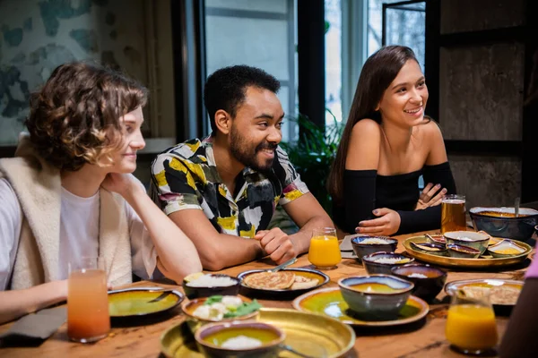 Jeunes amis multi-ethniques célébrant quelque chose dans un café — Photo