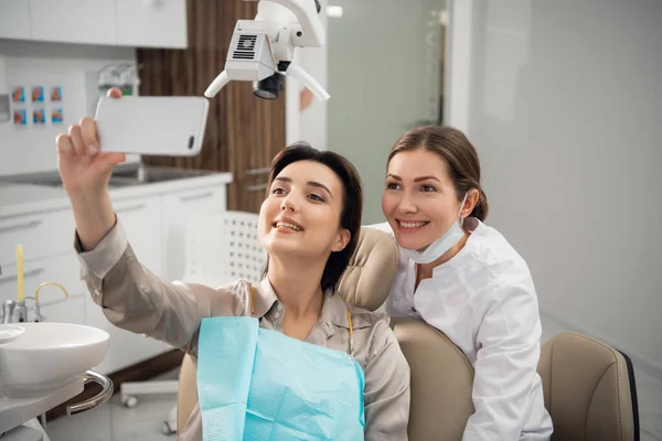 Γιατρός και ασθενής selfie στο χειρουργείο. Ευτυχισμένος ασθενής κρατά ένα έξυπνο τηλέφωνο — Φωτογραφία Αρχείου