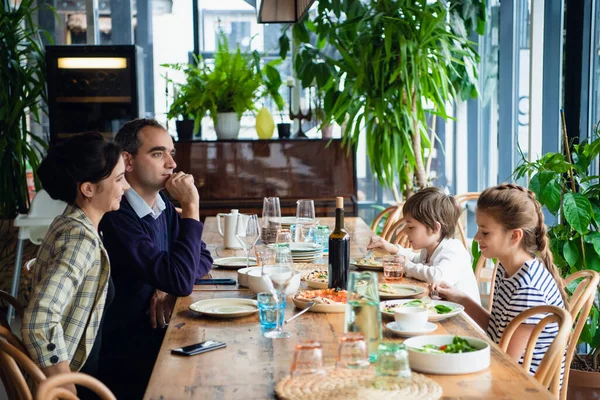 Une famille de quatre personnes dînant dans un café — Photo