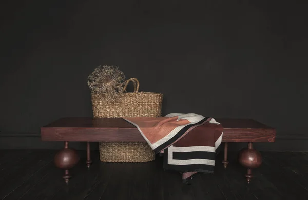 黑色房间里的木制长椅 草篮和纺织品 — 图库照片