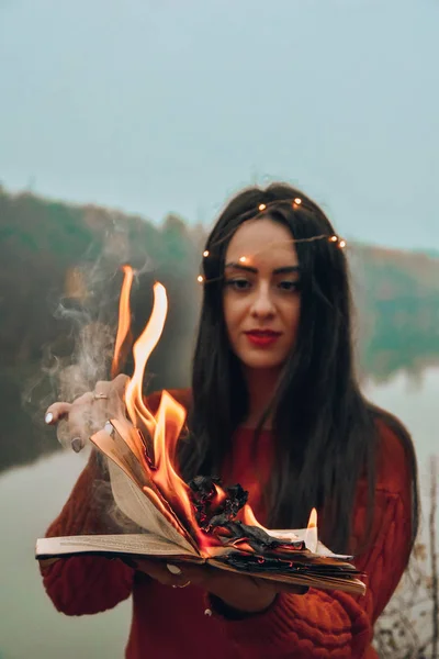 girl holding burning book flame bonfire magic