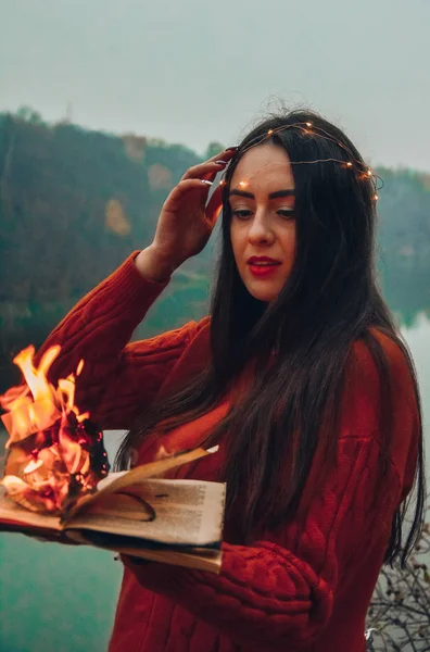 girl holding burning book flame bonfire magic