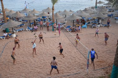 İnsanlar plaj voleybolu oynuyor.