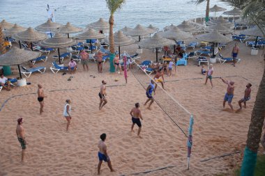 İnsanlar plaj voleybolu oynuyor.