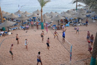 İnsanlar plaj voleybolu oynuyor.