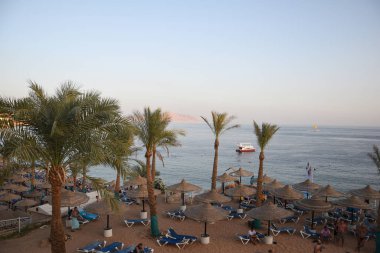 Sahilde güverte sandalyeleri ve şemsiyeleriyle