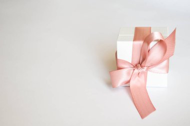 Beyaz arka planda pembe kurdeleli beyaz hediye kutusu. Noel ya da Sevgililer Günü Pembe kurdeleli beyaz hediye kutusu.