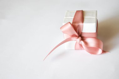 Beyaz arka planda pembe kurdeleli beyaz hediye kutusu. Noel ya da Sevgililer Günü Pembe kurdeleli beyaz hediye kutusu.
