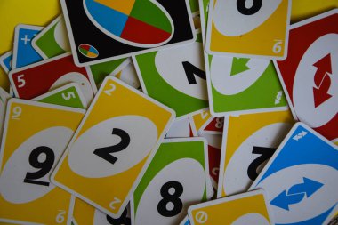 İngiltere, Londra - 4 Aralık 2019 Uno oyun kartları masanın her tarafına saçıldı. Amerikan kart oyunu. Simgesel olarak düzenlenmiş unno iskambil kartları - ters.